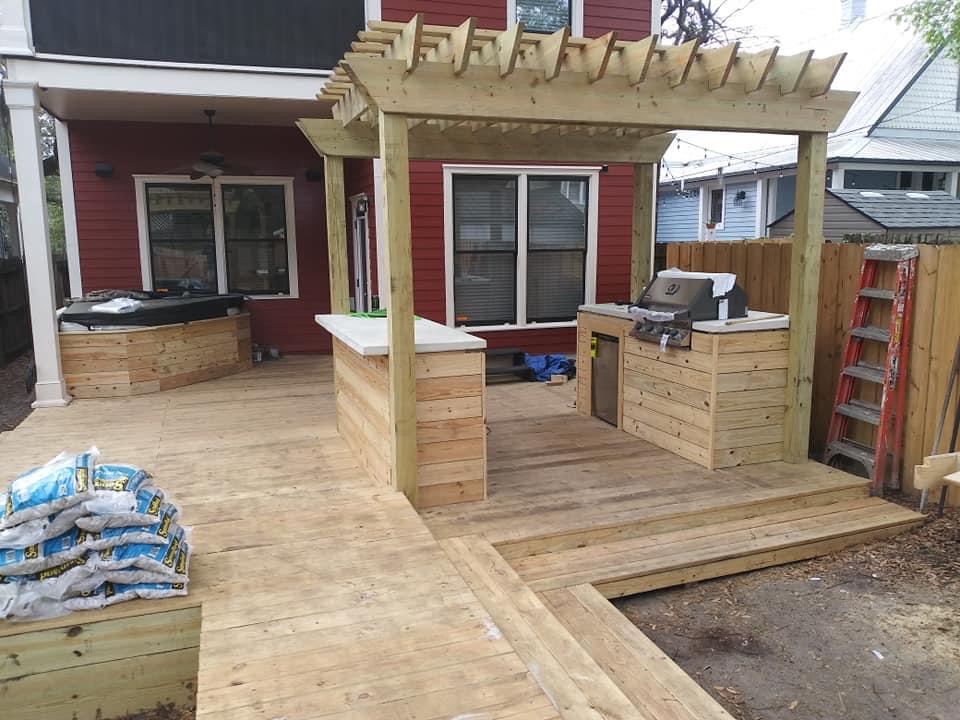 Outdoor kitchen with wooden deck, pergola, and grill area, custom-built in Jacksonville, FL