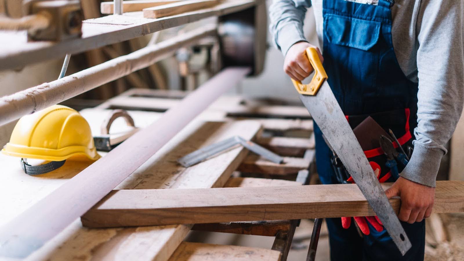 Craftsman using saw to cut wood for custom deck building.