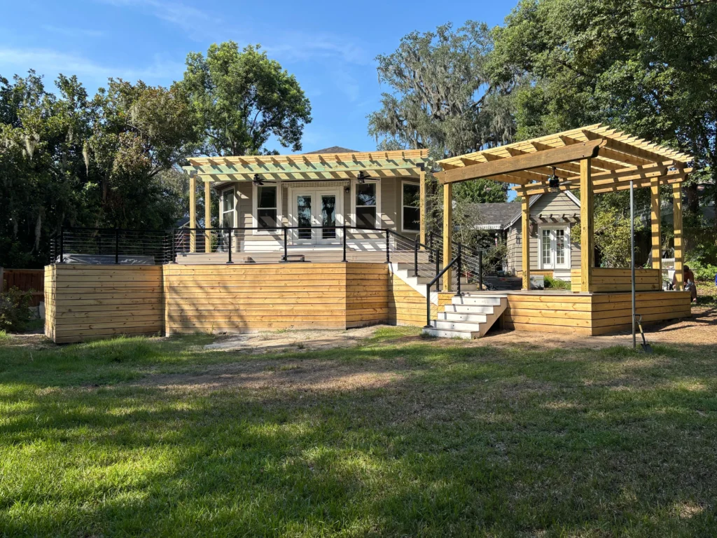 Custom wooden deck and pergola in backyard.