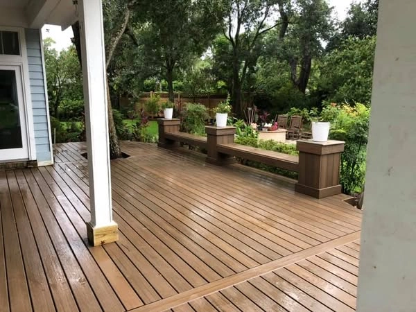 Composite deck with planters in green garden.