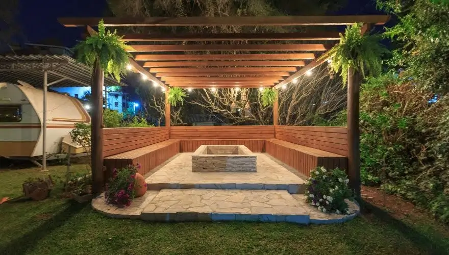 Cozy outdoor fire pit with deck and ambient lighting.