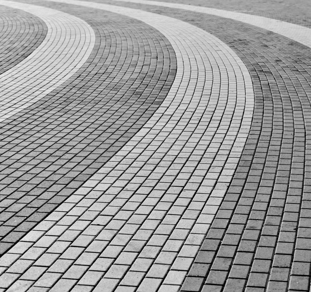 Curved pattern of commercial pavers for durable outdoor spaces.