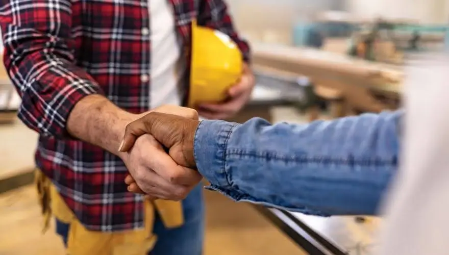Contractor shaking hands, symbolizing partnership in construction.