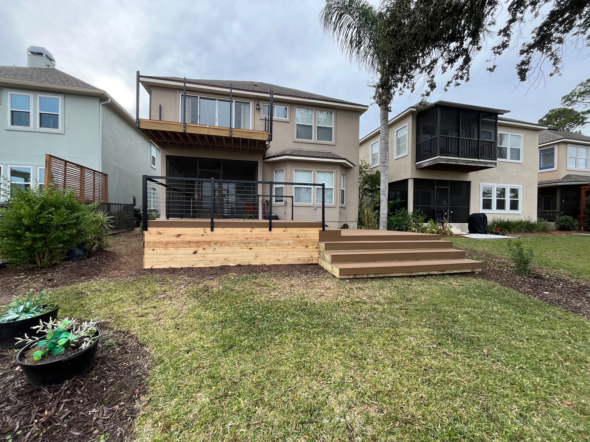 Modern wooden deck with steps and railing.