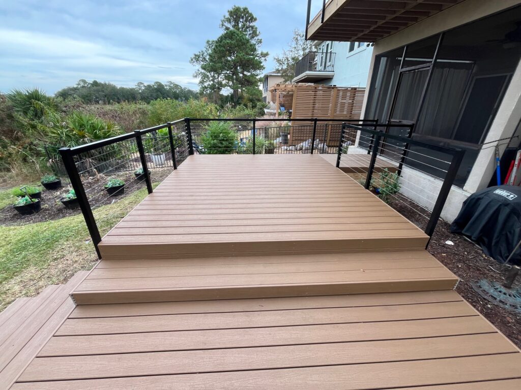 Composite deck with aluminum railing and landscaped garden.