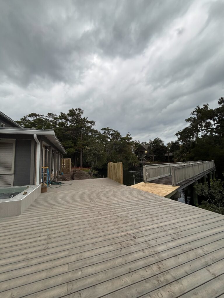 Composite deck overlooking water with cloudy sky backdrop.
