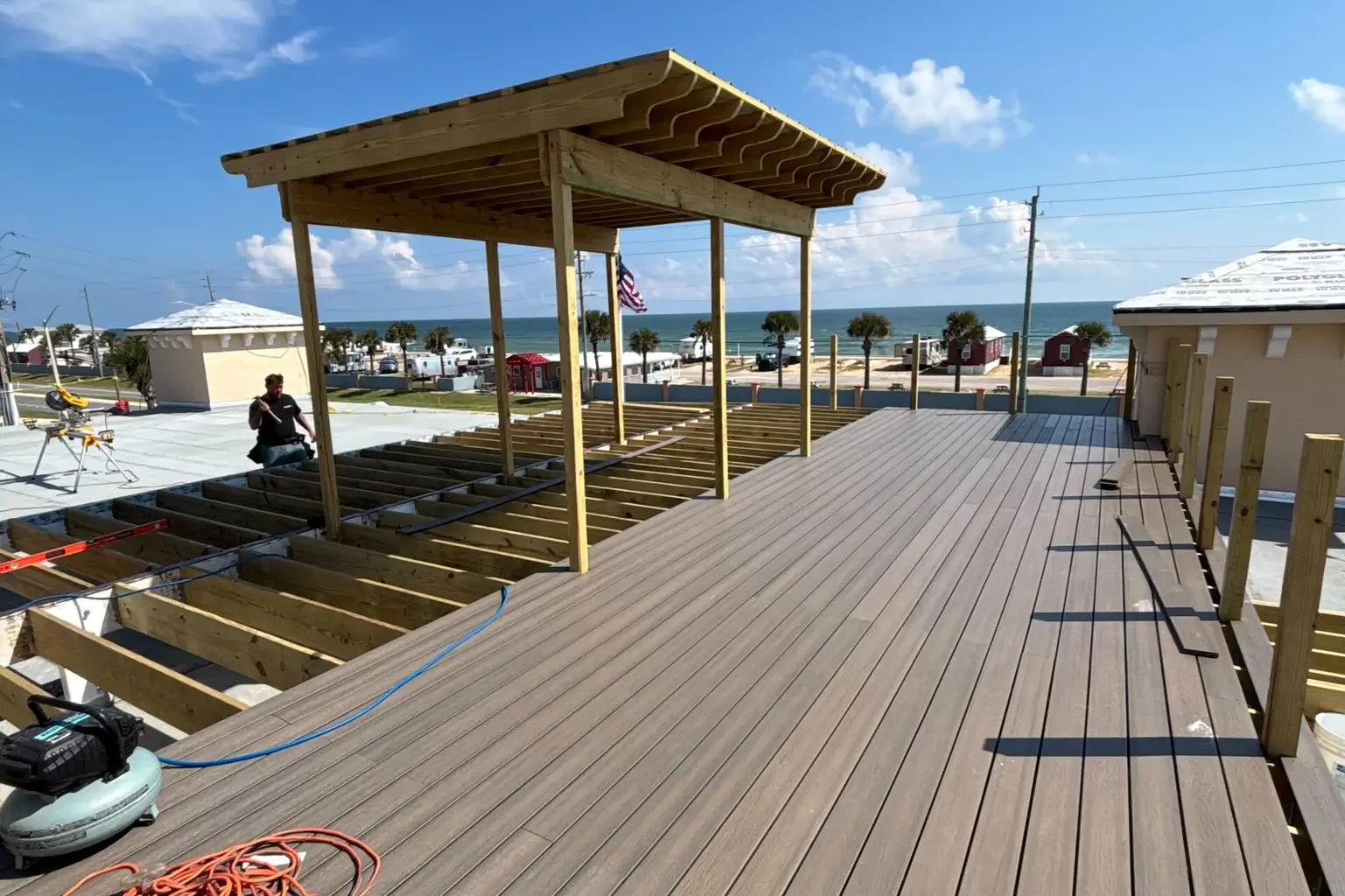 Rooftop deck construction with ocean view and framework.