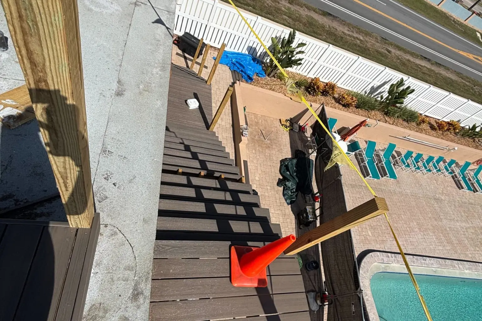 Rooftop deck construction with stairs and safety cone.