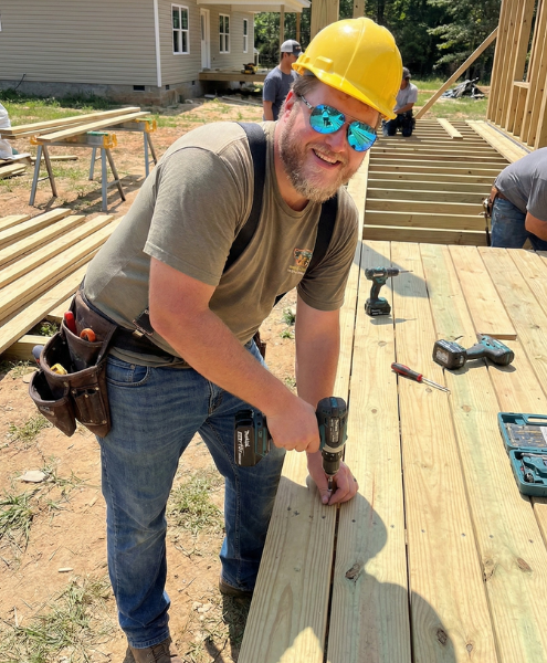 Deck builder installing wooden planks on a new deck project.