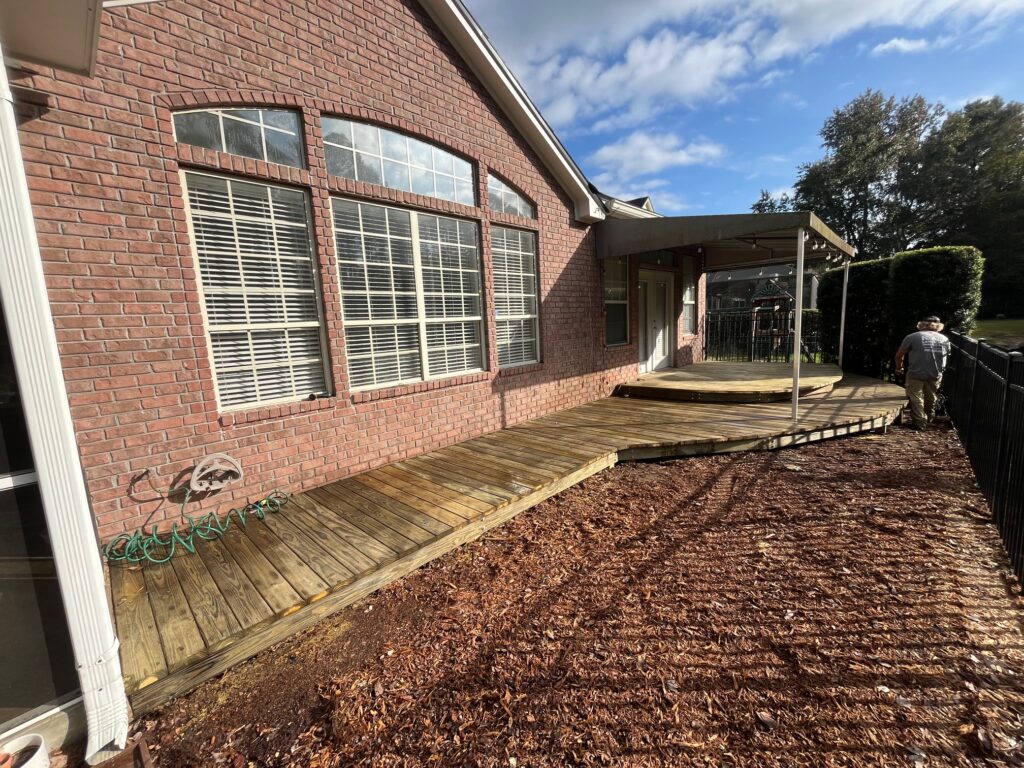 Curved wooden deck leading to a home entrance.